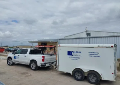 A white truck is parked in front of a building.