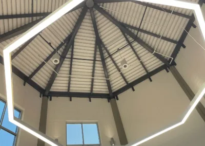 The ceiling of a building with a circular light fixture.